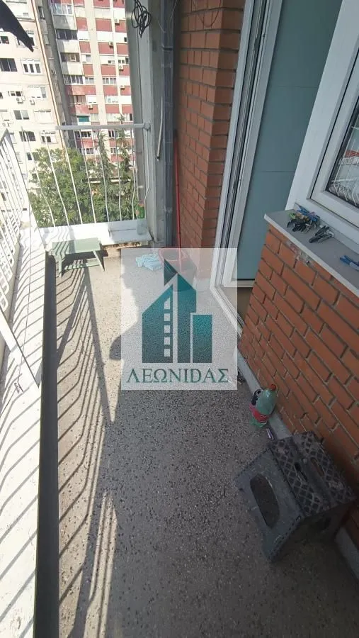 Manji balkon sa pogledom na okolne zgrade i ulicu.