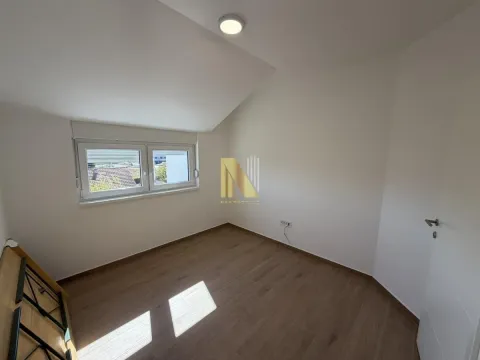 Empty room with a sloped ceiling and wooden flooring. - image 4