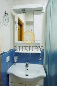 View of the bathroom with a sink and a mirror. - image 5