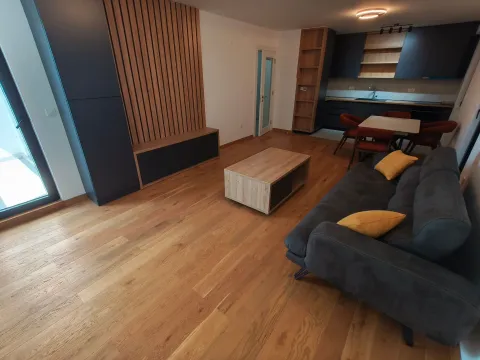 Dnevna soba povezana sa trpezarijom i kuhinjom, sa garniturom i drvenim podom. - image 5