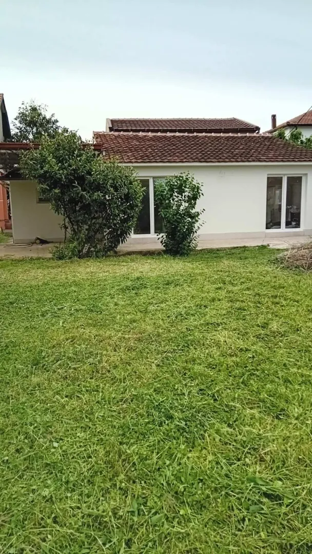 Pogled na dvorište i zadnji dio kuće sa travnjakom.