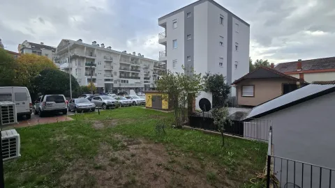 View of the building courtyard with surrounding buildings and parked cars. - image 9