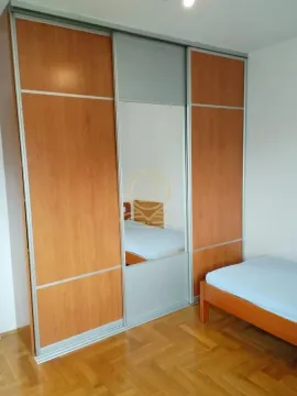 Spavaća soba sa drvenim krevetom i velikim ugradnim garderoberom sa ogledalom. - image 9