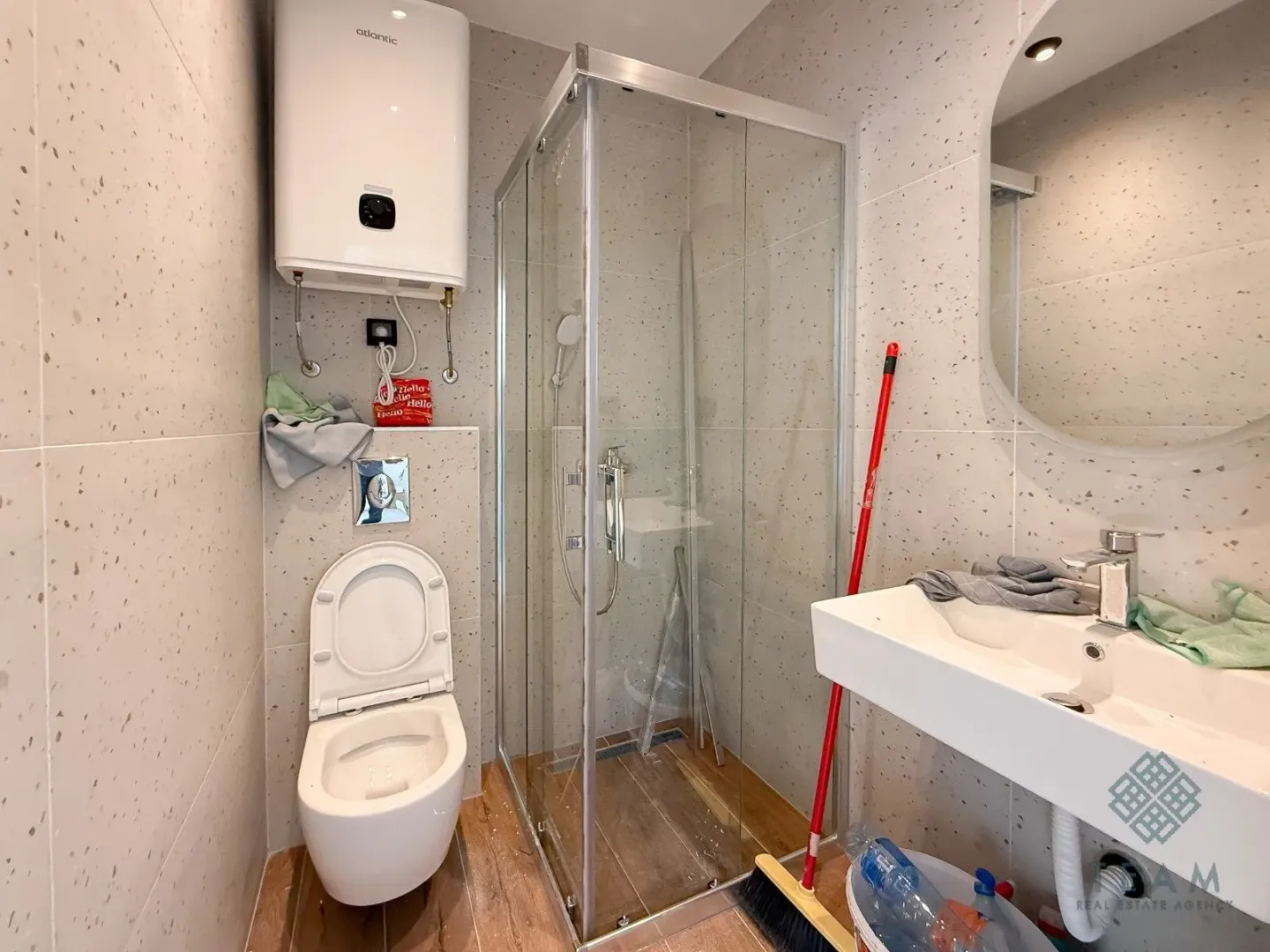 Bathroom equipped with a shower cabin, washbasin, toilet, and water heater.