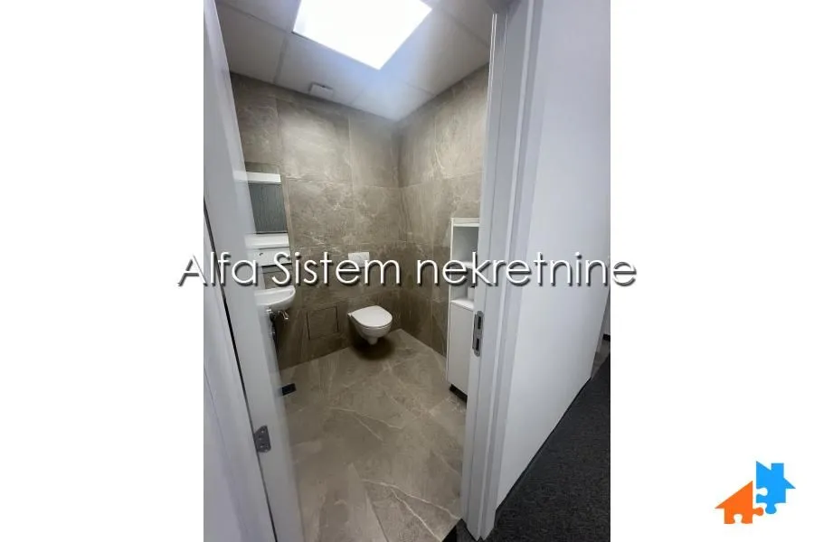View through the doorway into a furnished bathroom with ceramic tiles and sanitaryware.