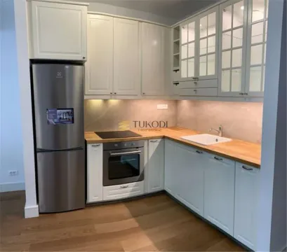 Kitchen equipped with white cabinetry, wooden countertops, and built-in home appliances. - image 12