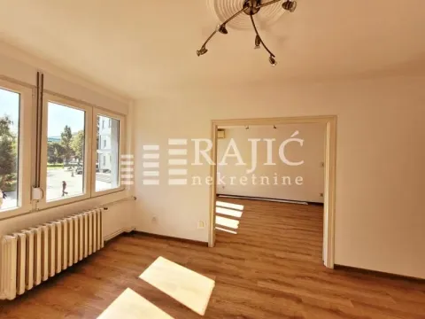 Empty room with wooden flooring and large windows. - image 6