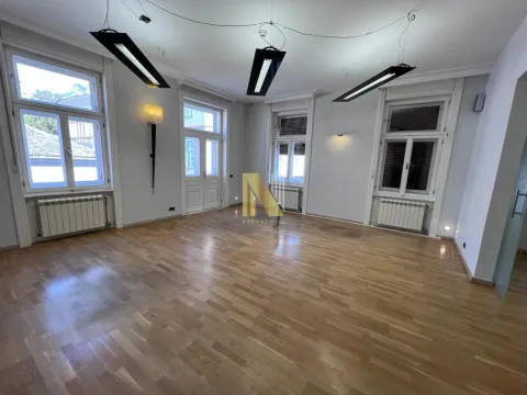 Spacious empty room with wooden flooring and large windows. - image 12