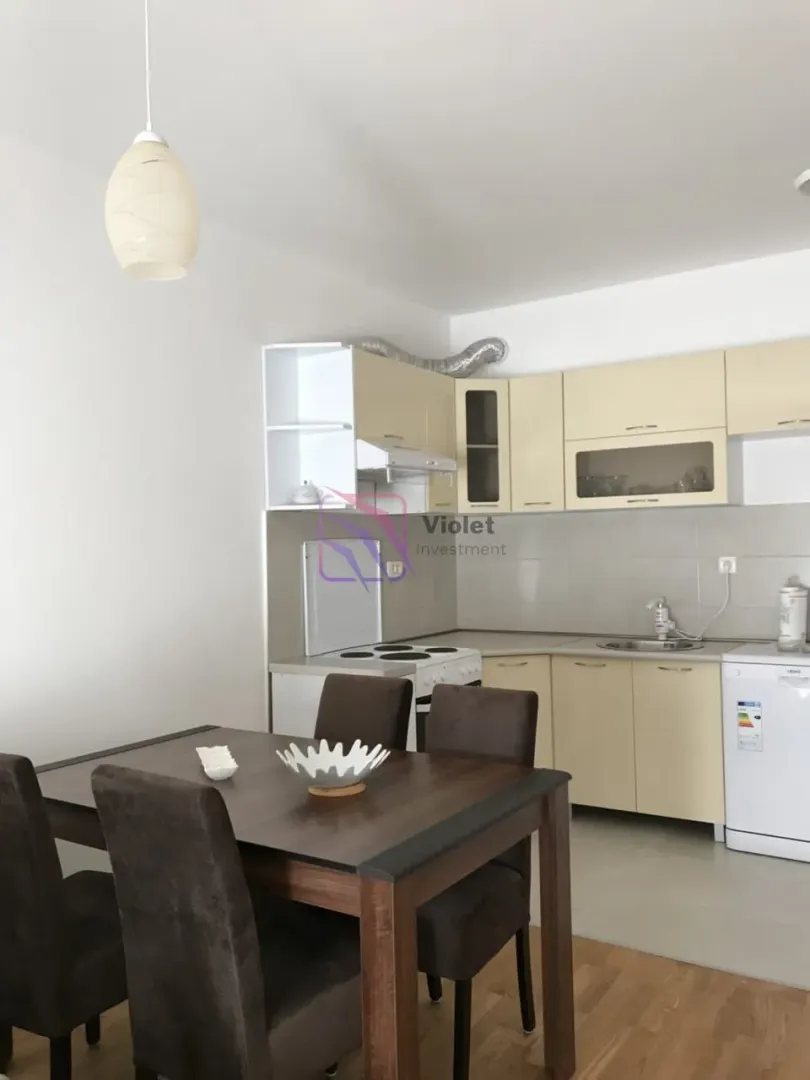 Kitchen with dining area and light wood cabinetry.