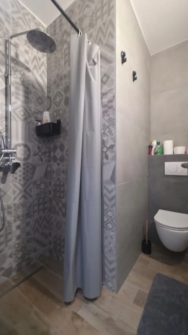 Moderne kupatilo sa tuš kabinom i ugradnom wc šoljom.