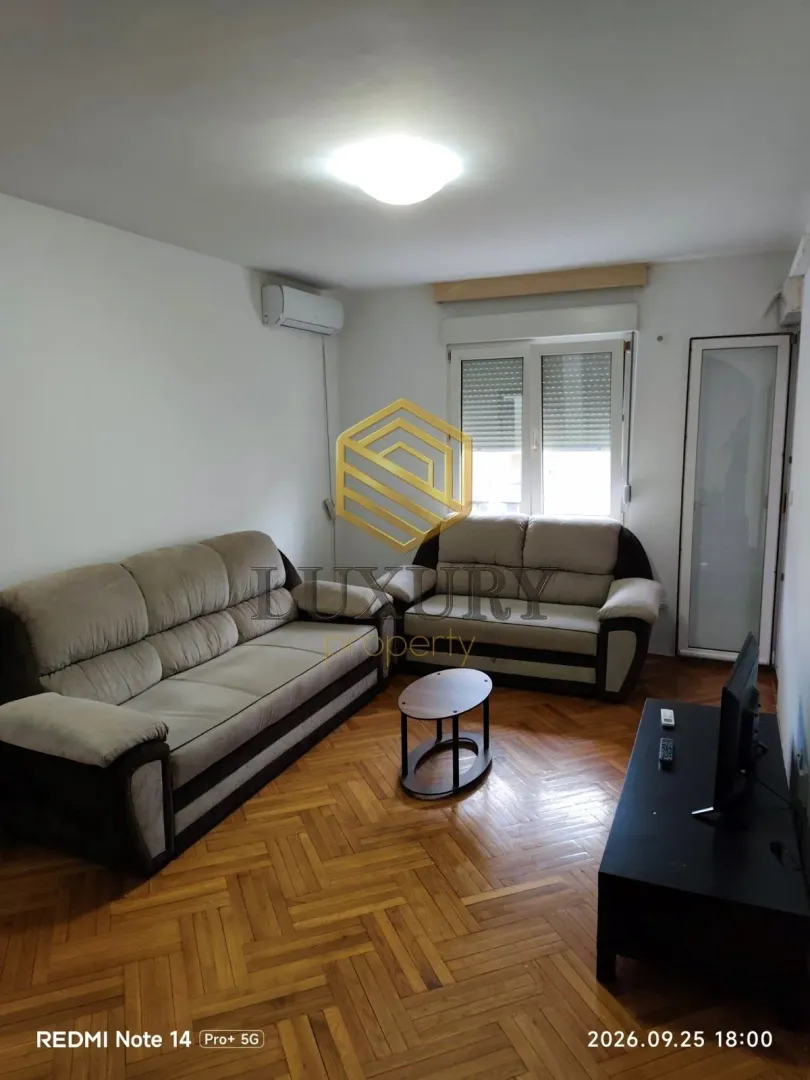 Living room with sofa set, coffee table, and TV.