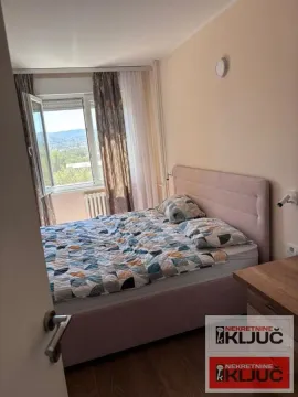 Spavaća soba sa bračnim krevetom i prozorom koji gleda na okolinu. - image 7