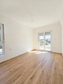 Prazna soba sa drvenim podom, bijelim zidovima i balkonskim vratima. - image 5