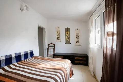 Spavaća soba sa bračnim krevetom, komodom i prozorom. - image 11