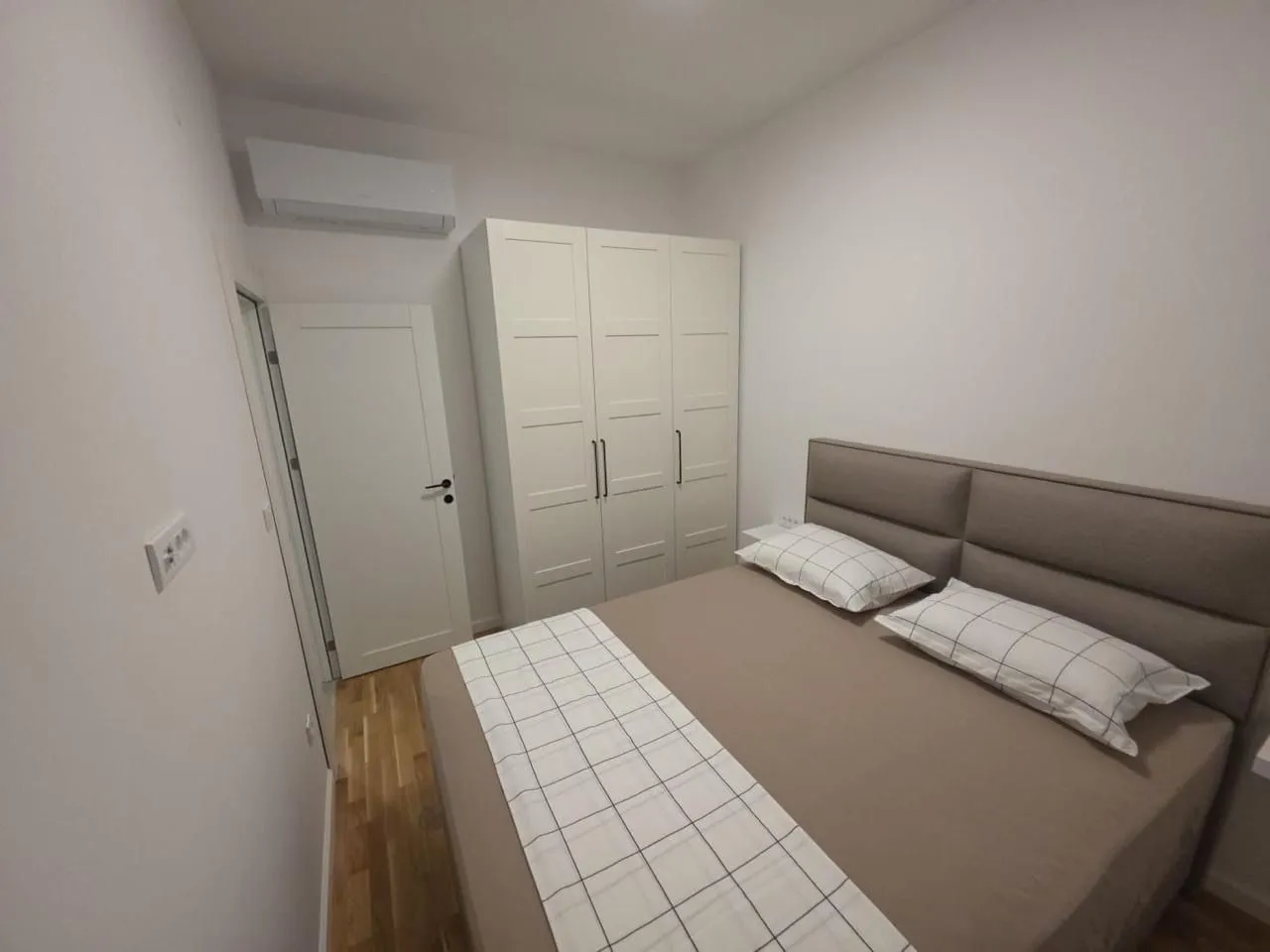 Furnished bedroom with a double bed and a wardrobe.