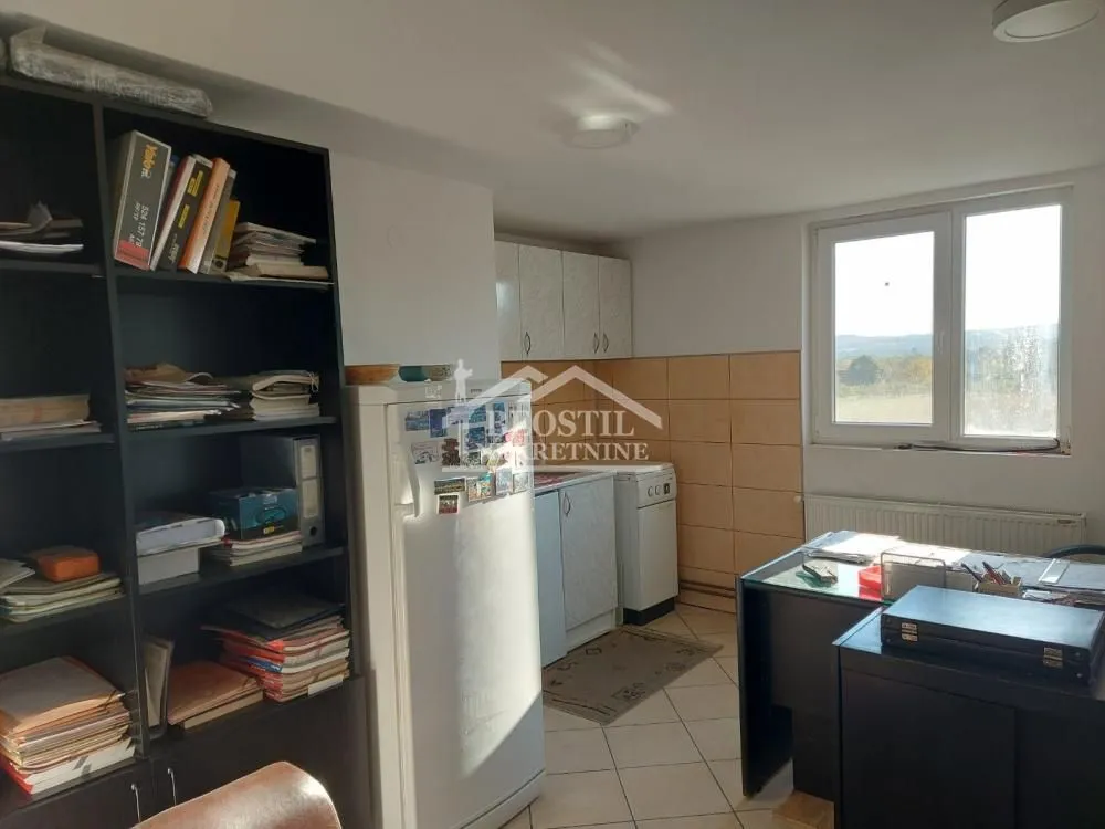 Kitchen equipped with kitchen units, a refrigerator, and a desk.