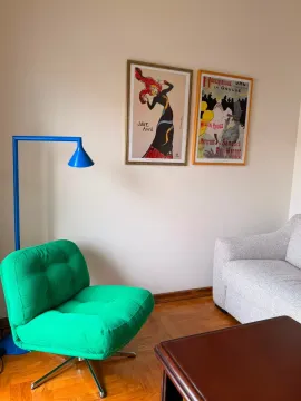 Dio dnevnog boravka sa zelenom foteljom i umjetničkim slikama na zidu. - image 7