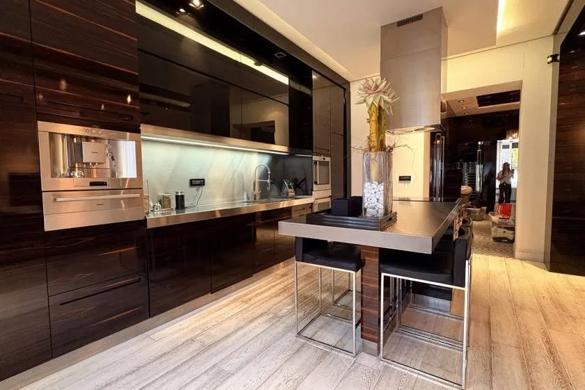 Modern kitchen with dark cabinetry, an island, and built-in appliances.