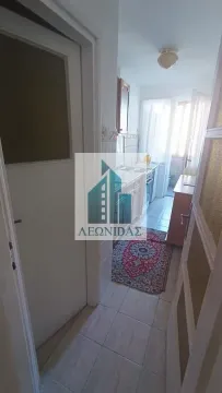 View of a smaller kitchen with a hallway and cabinetry. - image 8