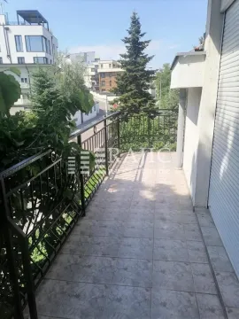 Spacious tiled balcony with metal railing and view of surrounding buildings. - image 12