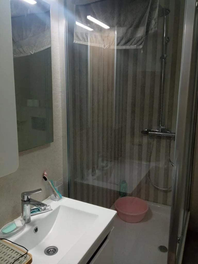 Bathroom with a washbasin and a shower cabin.