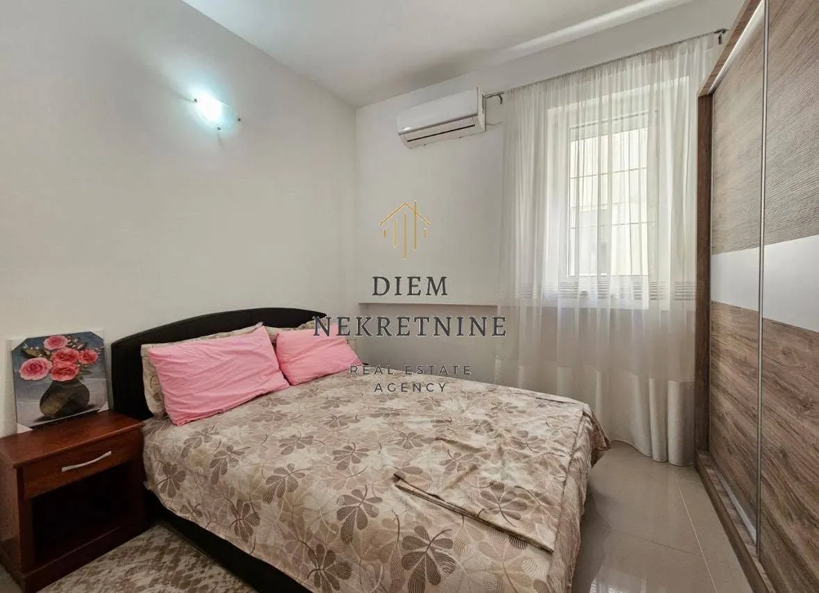 Furnished bedroom with a double bed and a wardrobe.