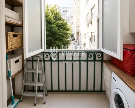 Zastakljeni balkon sa policama za odlaganje, veš mašinom i pogledom na ulicu. - image 8
