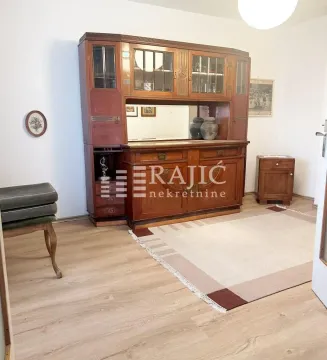 Living room with a large wooden cabinet and a rug. - image 5