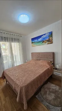 Namještena spavaća soba sa bračnim krevetom, noćnim stočićima i velikim prozorom. - image 5