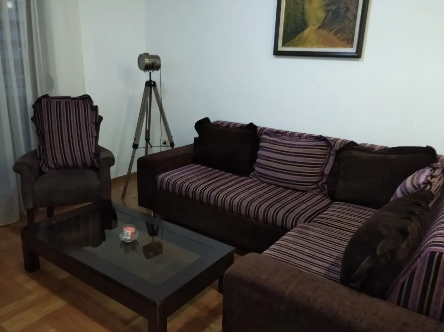 Dnevna soba sa garniturom, foteljom i stočićem.