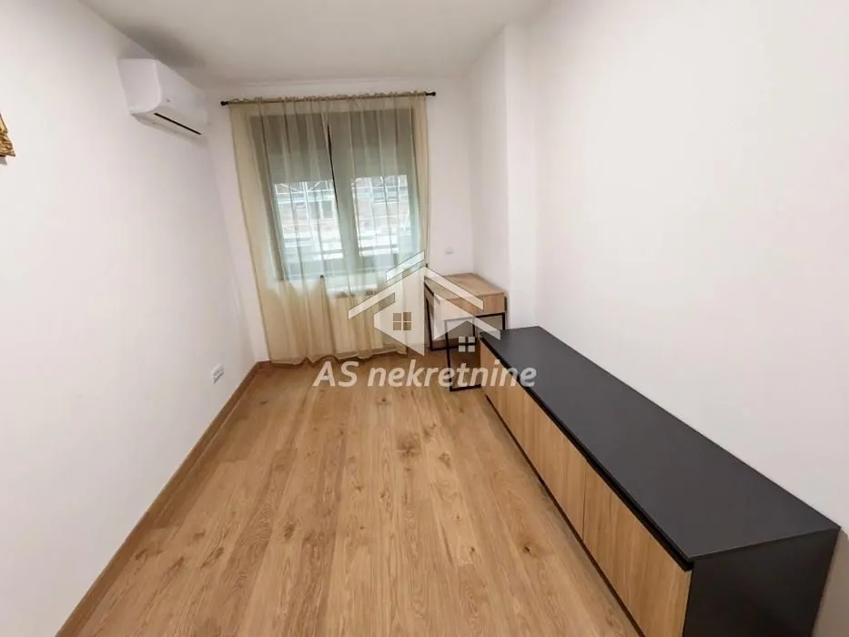 Smaller room with parquet flooring, window and a chest of drawers.