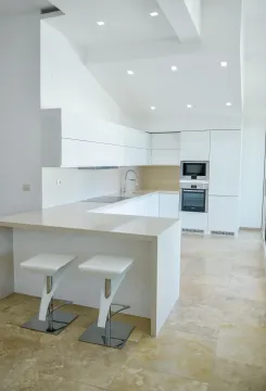 Moderna bijela kuhinja sa šankom i ugradnim elementima. - image 3