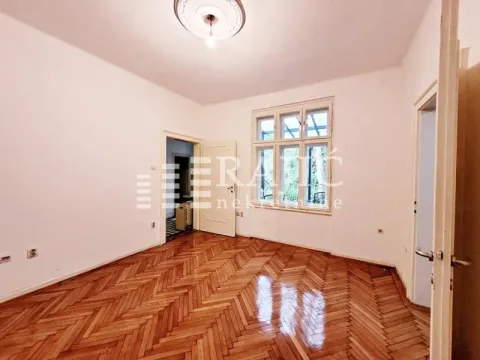 Empty room with parquet flooring and a large window. - image 7