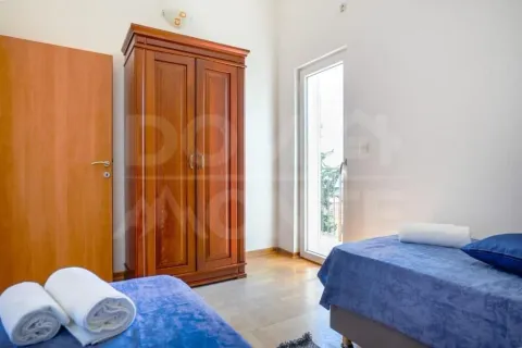 Bedroom with two beds, wooden wardrobe, and access to the terrace. - image 5