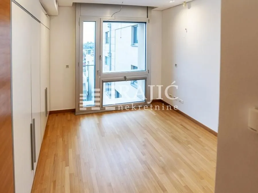 Empty room with wooden flooring and built-in closets.