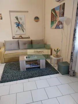Dnevna soba sa kaučem, stočićem i slikama na zidu. - image 3