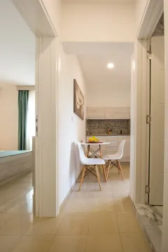 View from the hallway towards the kitchen with a dining table and chairs. - image 6