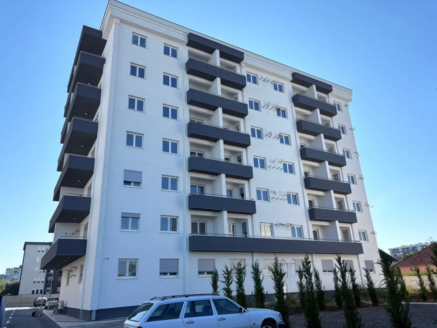 Pogled na spoljašnjost moderne stambene zgrade sa terasama.