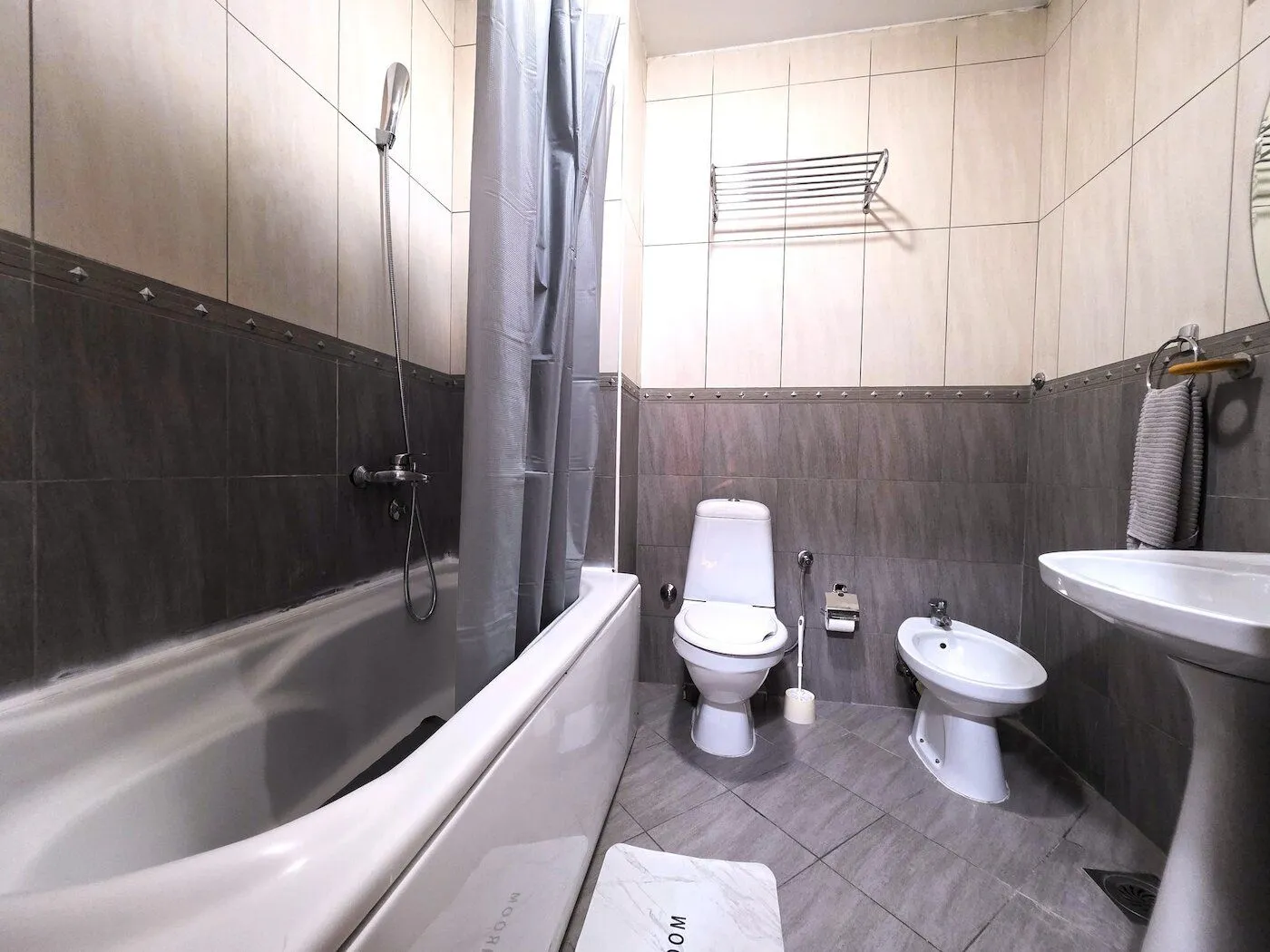 Fully equipped bathroom with a bathtub, toilet, and washbasin.