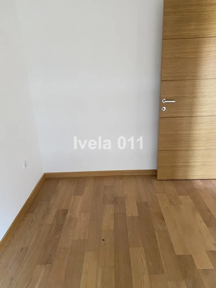 Prazna soba sa drvenim podom i vratima.