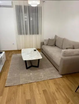 Dnevna soba sa garniturom, stočićem i parketom na podu. - image 2