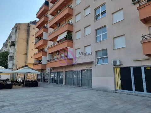Facade of a residential building with commercial space on the ground floor and a paved plateau in front. - image 3
