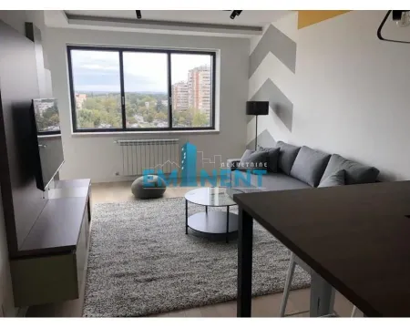 Living room with a sofa, TV unit, and a window with a city view. - image 11