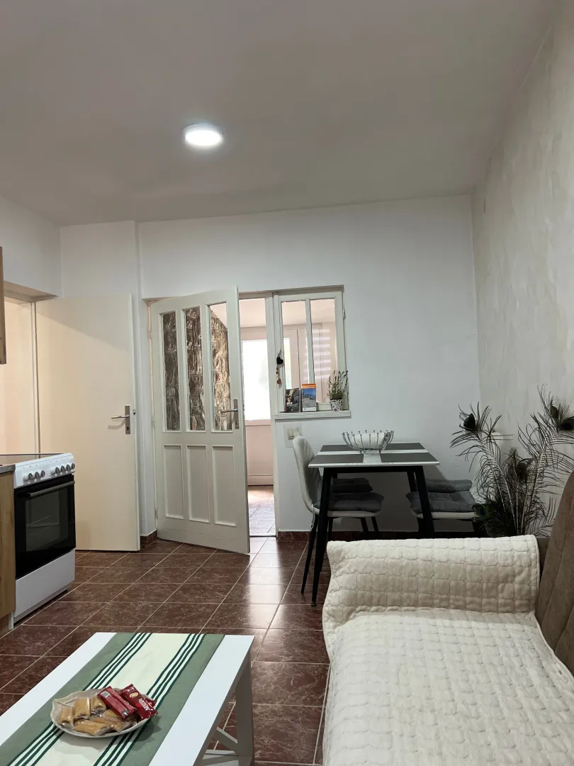 Living room with a dining table and kitchen units.