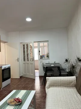 Living room with a dining table and kitchen units. - image 4