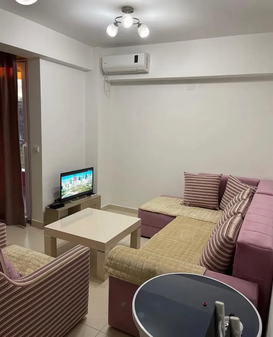 Living room with sofa, coffee table, and television.