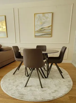 Dining table with four chairs on a light rug in the living room. - image 6