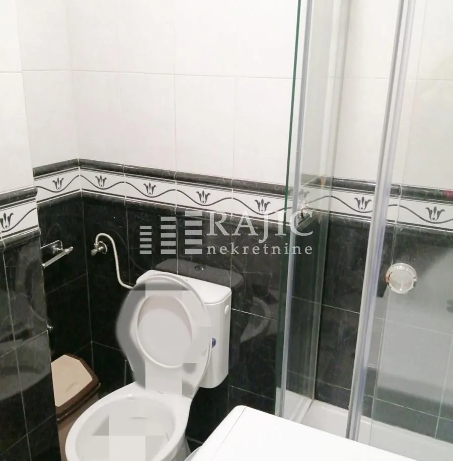 Bathroom with toilet and shower cabin.