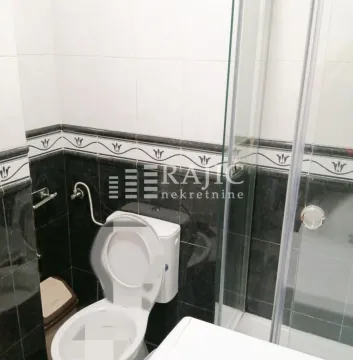 Bathroom with toilet and shower cabin. - image 2