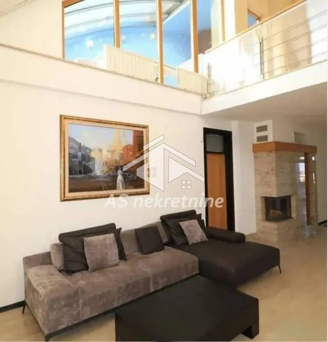 Spacious living room with a sofa set and a mezzanine gallery upstairs.